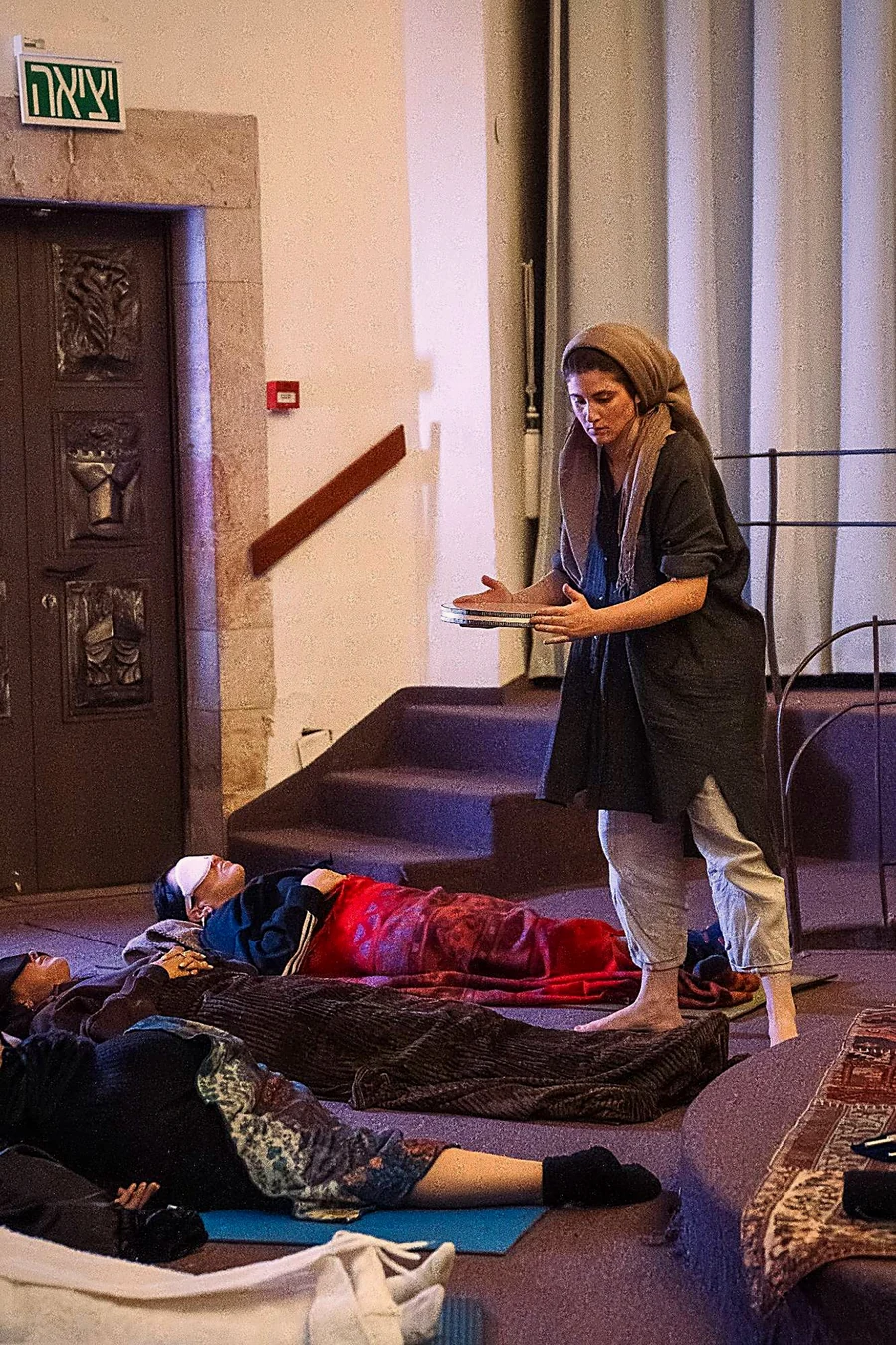 Tanya leading a sound bath as women rest in deep relaxation